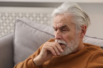 Amnesia. Senior man trying to remember something at home