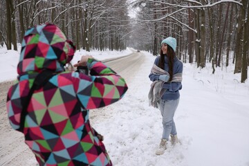 Obraz premium Professional photographer taking picture of woman outdoors on winter day