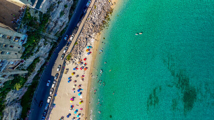 Fototapeta premium Aerial overhead view of Tropea beach with turquoise sea and sun umbrellas in Calabria