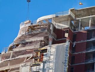 Historic brick exterior undergoing meticulous repair and preservation with scaffolding present © Vladimir
