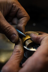 Fototapeta premium Gold ring being repaired by skilled jeweler in workshop.