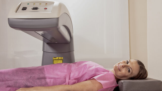 Woman in her 40s undergoing scan at bone densitometer machine