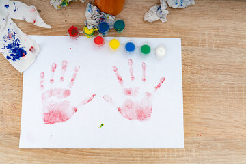 Hand prints made with colorful paint on paper during an art activity at a home setting