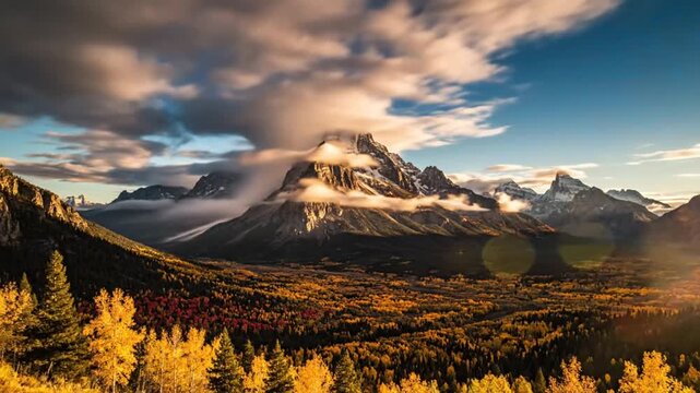 Epic scenic mountain range autumn landscape with gold and red fall foliage and clouds at sunset