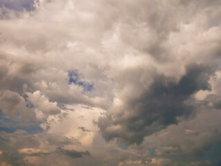 Obraz premium The sky is cloudy and the sun is shining through the clouds. The sky is blue and the clouds are white