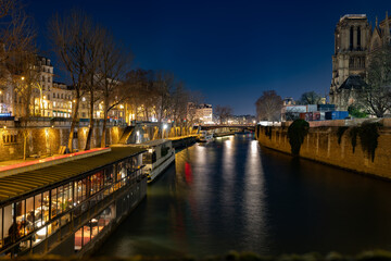 Obraz premium Night view of the Seine River in Paris with illuminated embankments and Notre Dame Cathedral