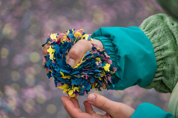 A child holds a handful of colorful confetti to celebrate the Fasnacht winter at the carnival...