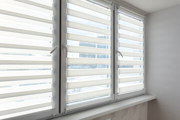 Obraz premium Modern White Zebra Roller Blinds on Window with Sunlight and City View