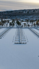 Fototapeta premium Ithaca, NY, USA. 01-24-2026 Vertical winter aerial photo of frozen, snowy marina, docks at Allan H Treman State Marine Park,