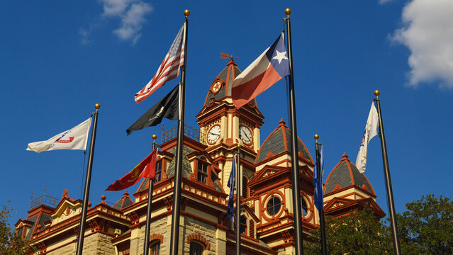 Flags in front of the Caldwell County Courthouse in Lockhart, Texas USA