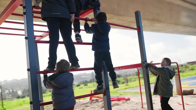 Group of active children playing on monkey bars at playground