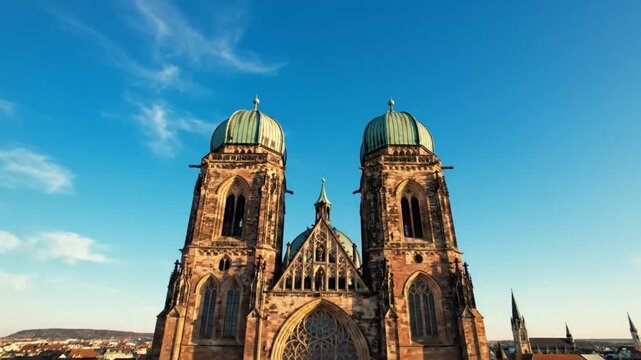 Drone perspective of St. Lorenz Church in Nuremberg, Germany, on a sunny day with blue skies and clouds