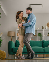 Cheerful couple dancing laughing having fun at home