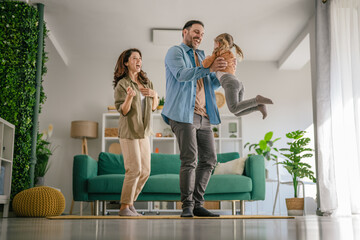 Fototapeta premium Happy family playing together in bright living room