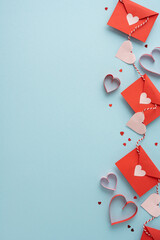 A vertical vertical composition shows red envelopes threaded by striped twine with pink heart...