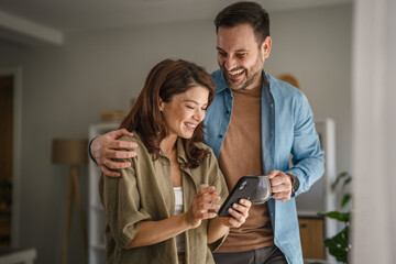 Happy couple sharing content on smart phone at home