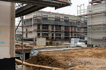 construction site showing an unfinished apartment building. House under construction. shell construction with building material, tools and scaffolding. future property real estate