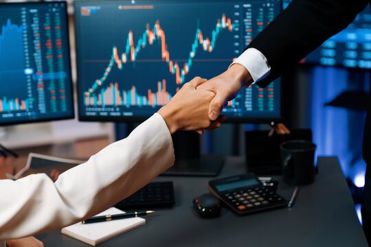 Cropped hand of business partner checking hand with dynamic stock market data analyzing profit value currency rate online website program application background pc screen at modern office. Infobahn.