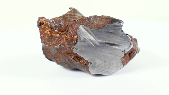 Rotating Of An Iron Meteorite. White background on a white base. general plan. Rust on the surface