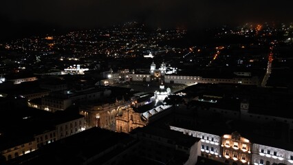 Obraz premium Aerial Night View of Quito Historic Center, Ecuador. Stunning aerial drone footage of Quito’s Historic Center at night, Ecuador. Illuminated colonial churches, historic buildings, and narro