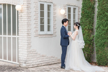 Naklejka premium Bride and groom in the garden of the wedding venue (garden wedding)