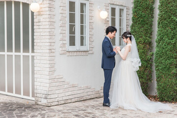 Naklejka premium Bride and groom in the garden of the wedding venue (garden wedding)