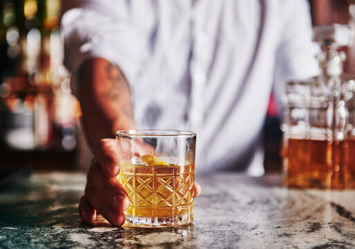 Bartender serving up a whiskey cocktail