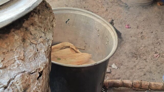 Detail of tamales wrapped in husks inside a steamer pot, traditional cooking method