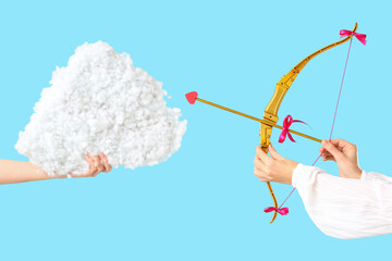 Naklejka premium Female hands with cupid's bow and decorative cloud on color background. Valentine's Day celebration