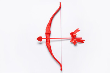 Naklejka premium Red cupid's bow with arrow on light background. Valentine's Day celebration