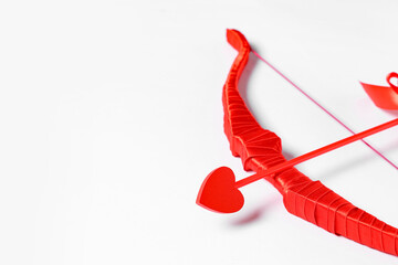 Naklejka premium Red cupid's bow with arrow on light background. Valentine's Day celebration