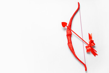 Naklejka premium Red cupid's bow with arrow on light background. Valentine's Day celebration