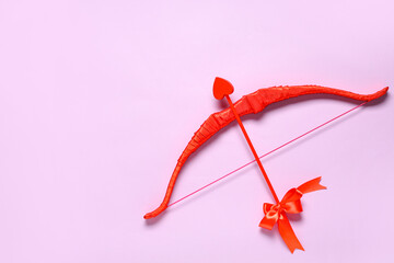 Naklejka premium Red cupid's bow on lilac background. Valentine's Day celebration