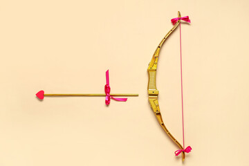 Naklejka premium Golden cupid's bow with arrow on color background. Valentine's Day celebration