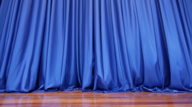 Deep blue pleated drapes hang over a wooden floor