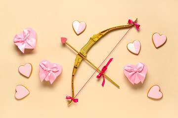 Naklejka premium Composition with cupid's bow and heart shaped cookies on color background. Valentine's Day celebration