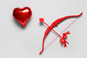 Naklejka premium Cupid's bow and heart shaped balloon on grey background. Valentine's Day celebration