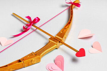 Naklejka premium Composition with cupid's bow and paper hearts on grey background, closeup. Valentine's Day celebration