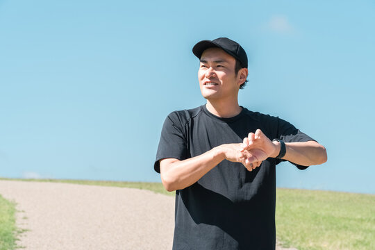 A middle-aged man in sportswear using a smartwatch, pedometer, and pedometer to manage his health and wellness