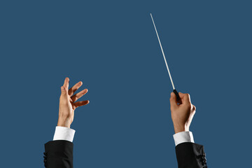 Naklejka na ściany i meble Hands of male conductor with baton on blue background