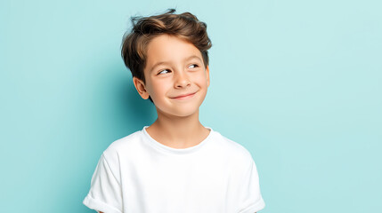 A young boy with a cheerful expression standing against a light blue background