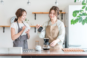 A female instructor and a female student teaching how to brew coffee at a coffee class/coffee school