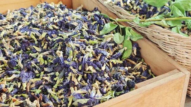 Dried butterfly pea flowers, placed on a wooden tray, can be brewed into a healthy drink.