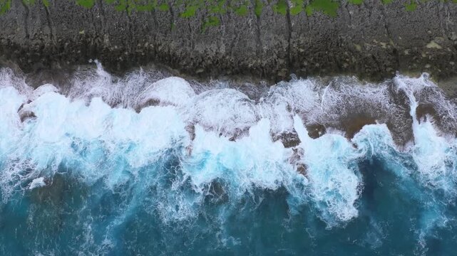 Witness the powerful convergence of history and nature. This dramatic drone footage captures the rugged northern coastline of Saipan, featuring the towering Banzai Cliff and Suicide Cliff. The deep bl
