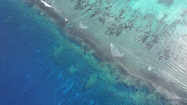 "A stunning aerial drone shot capturing the calm and crystal-clear emerald waters of Saipan&rsquo;s west coast. Features beautiful coral reefs visible through the transparent sea."