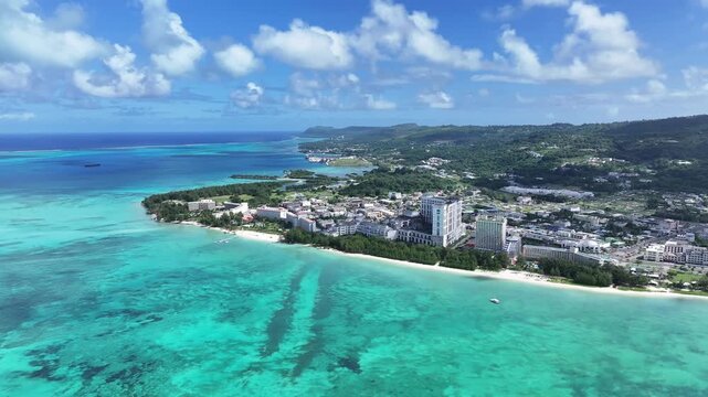 Discover the gateway to the Northern Mariana Islands. This high-quality aerial view showcases the beautiful west coast of Saipan, featuring the iconic skyline of Garapan&rsquo;s luxury hotels and the expans