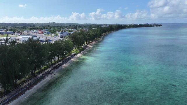 Trace the path of endurance in paradise. This sweeping aerial footage captures the renowned coastal running course along Saipan's west coast, famous for hosting international marathons. Stretching fro