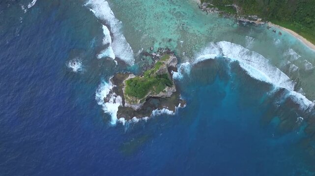 Witness the powerful convergence of history and nature. This dramatic drone footage captures the rugged northern coastline of Saipan, featuring the towering Banzai Cliff and Suicide Cliff. The deep bl