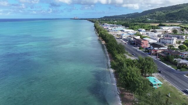Trace the path of endurance in paradise. This sweeping aerial footage captures the renowned coastal running course along Saipan's west coast, famous for hosting international marathons. Stretching fro