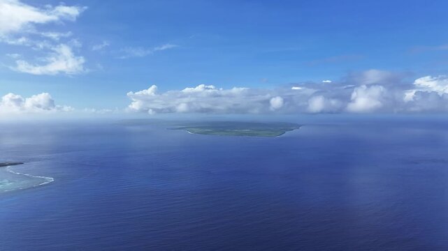 "A sweeping aerial view looking south from the beautiful west coast of Saipan toward Tinian Island. The deep blue Saipan Channel and turquoise lagoon provide a stunning backdrop for travel and nature